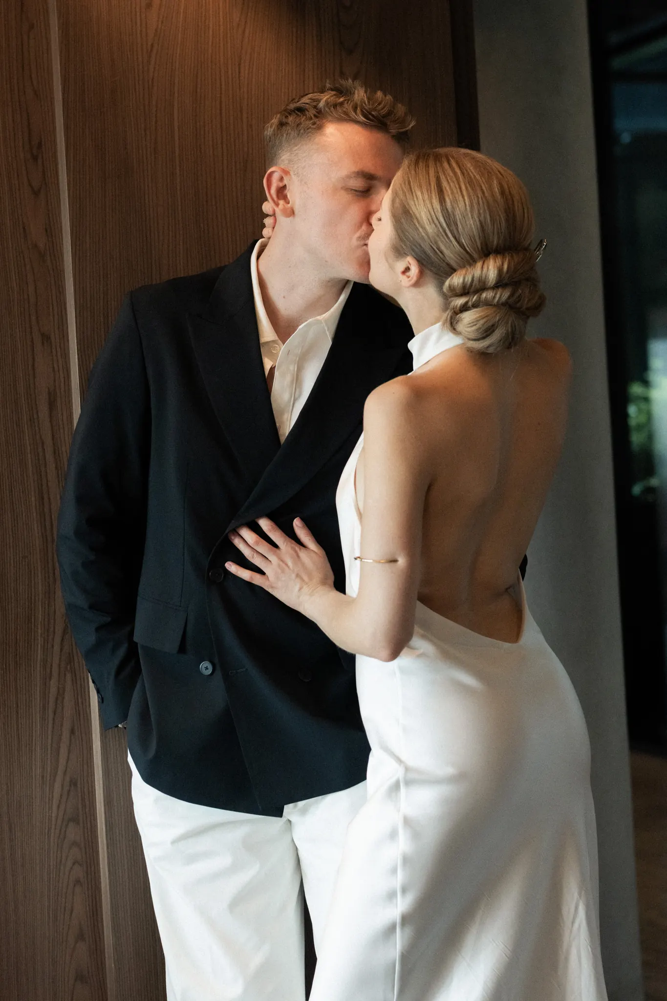 A kiss against a walnut-panelled wall