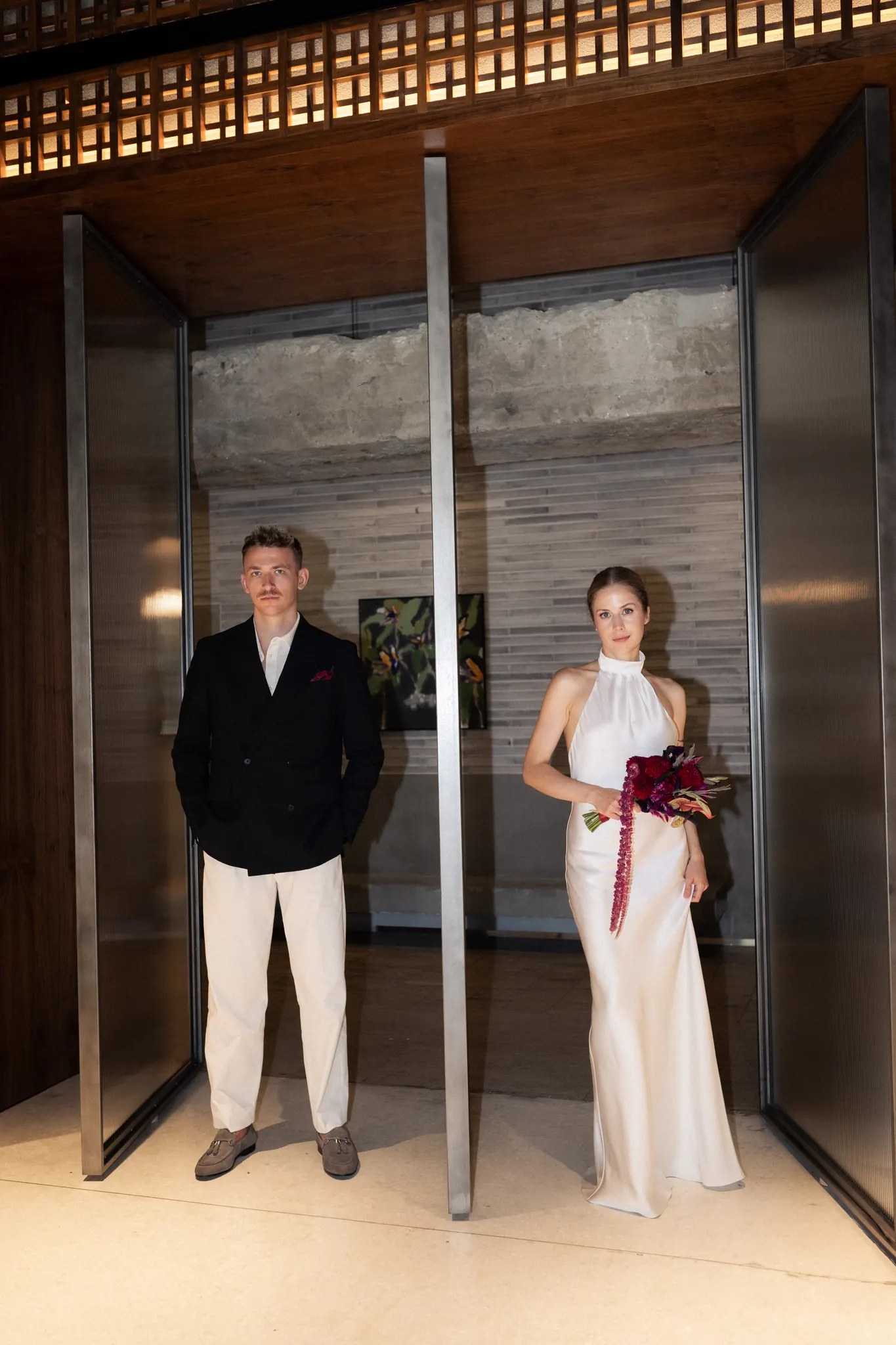 Veronika and Sasha standing apart between two glass doors