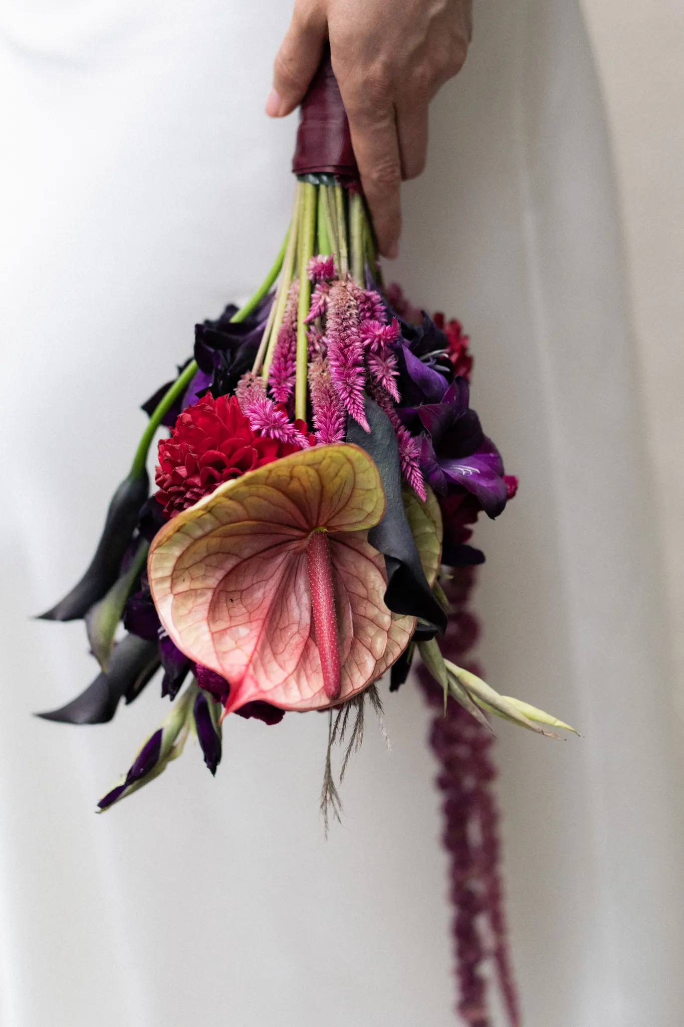 The bouquet held upside down against the dress
