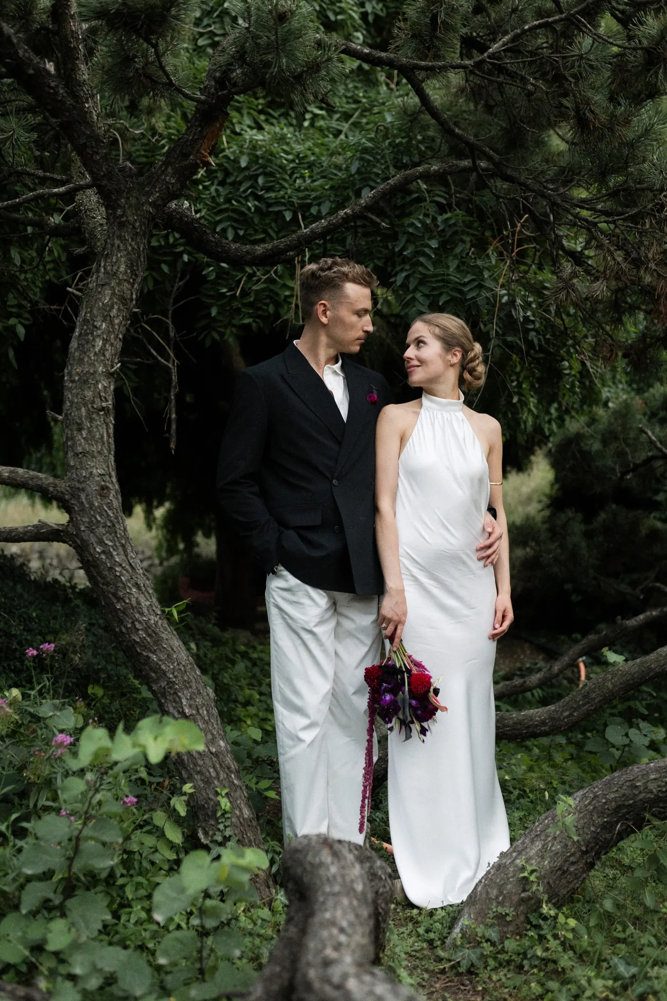 Veronika and Sasha under the branches of a pine tree