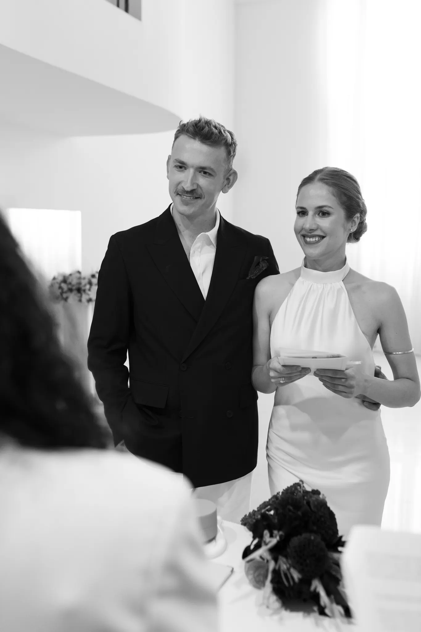Veronika and Sasha smiling at the registrar, black and white