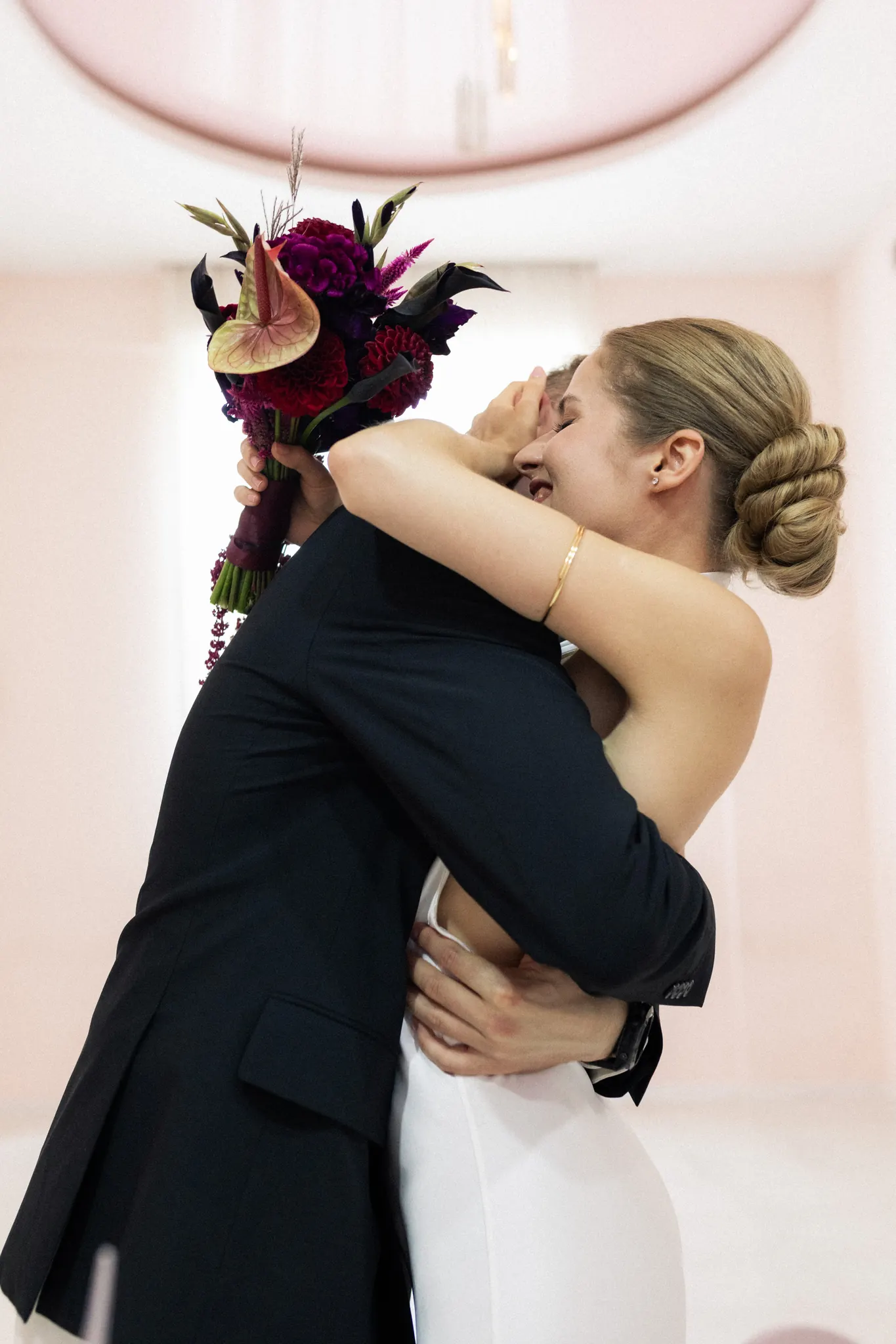 Veronika and Sasha embracing, the bouquet held high